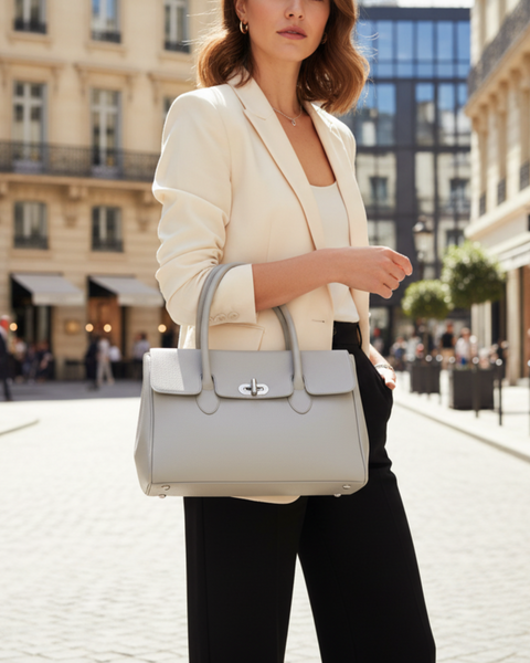 Large Light Grey Leather Coupè Handbag on the arm of a chic woman with a city backdrop - idPearl