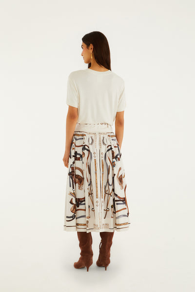 Winter white midi skirt with equestrian print, A-line cut, side zip, and worn with a beige top and brown boots.