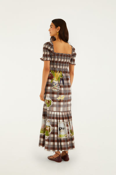 Brown tartan midi dress with smocked bodice, ruffled sleeves, and whimsical farm-themed prints. Features a square neckline.