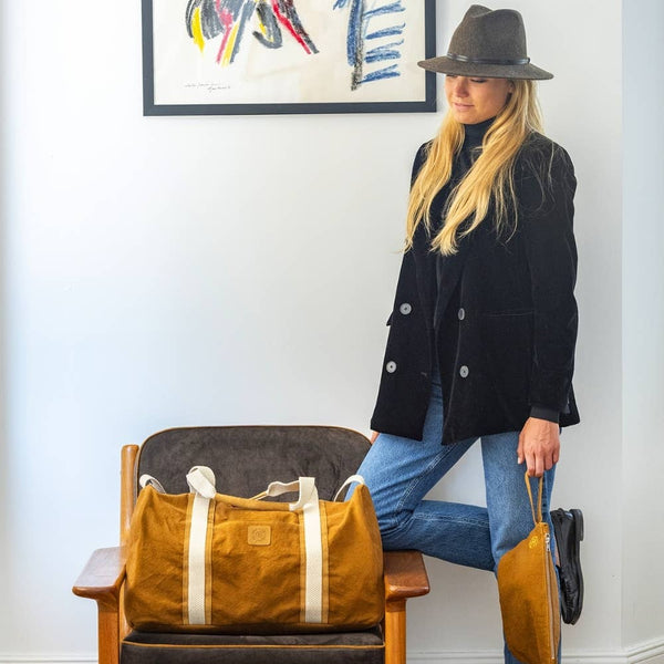 Wool felt fedora with leather trim worn by a model in a black blazer and jeans, styled against a minimalist backdrop.