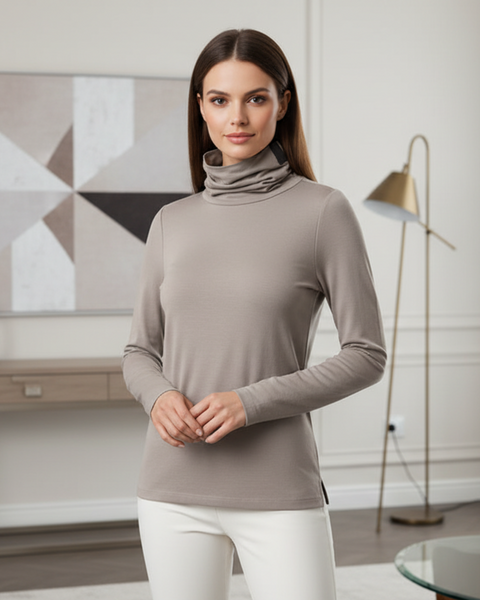Woman wearing a beige turtleneck top by Henriette Steffensen and white pants in a modern living room for idPearl