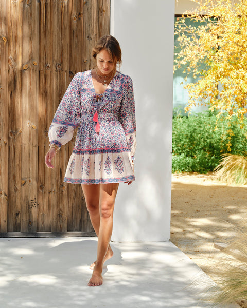 Della Floral Print Mini Dress in blue and pink cotton with V-neck, elastic waist, tiered skirt, and tassel detail