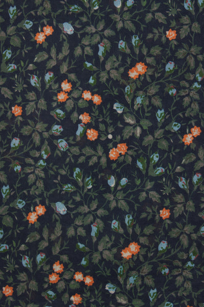 Navy cotton blouse with a ditsy floral pattern featuring orange flowers, showcasing a v-neckline and long shirred sleeves.