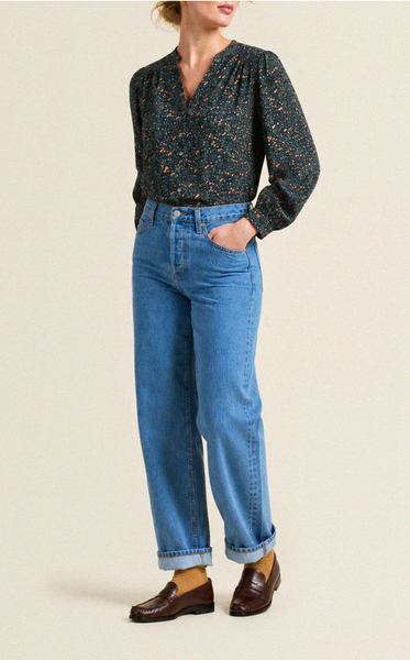 Navy floral blouse with a v-neckline and long sleeves, paired with light blue jeans and brown loafers.
