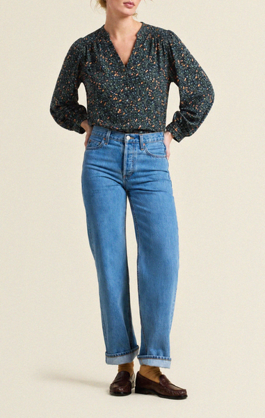 Navy floral blouse with a v-neckline and long sleeves, paired with rolled-up blue jeans and brown loafers.