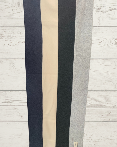 Striped fleece scarf in black, beige, and gray by Henriette Steffensen for idPearl on a wooden backdrop.